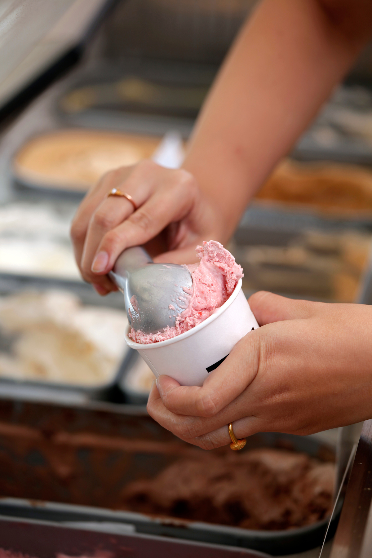 Hand scooping ice-cream to the cup